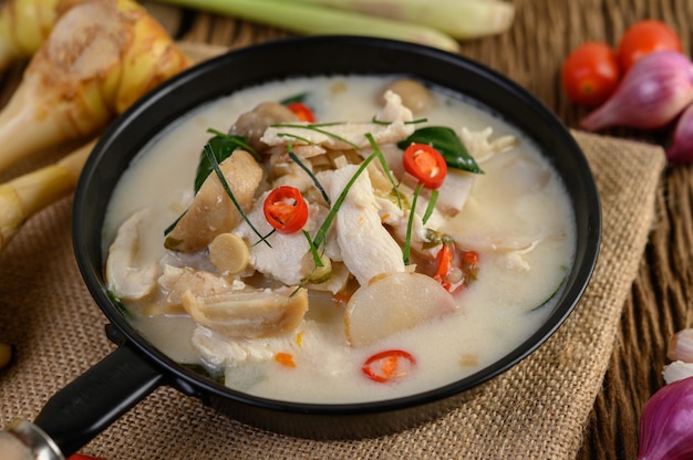 Tom Kha Kai in a pan frying with kaffir lime leaves, lemongrass, red onion, galangal and chilli.