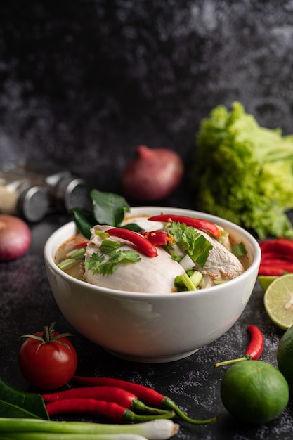 Free photo tom yum chicken with chili, coriander, dried chili, kaffir lime leaves, mushroom and lemongrass in a bowl