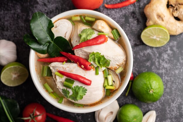 Tom yum chicken with chili, coriander, dried chili, kaffir lime leaves, mushroom and lemongrass in a bowl