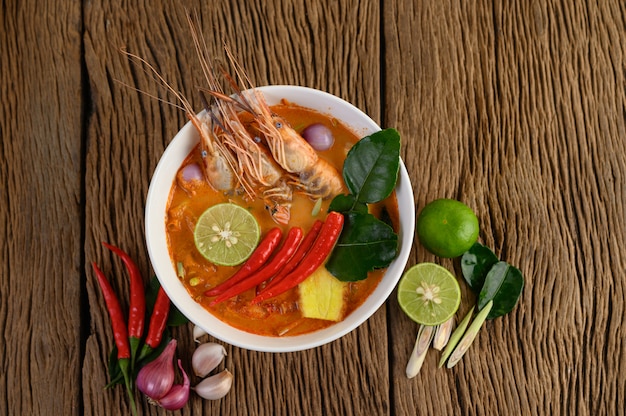 Tom Yum Kung Thai hot spicy soup shrimp with lemon grass,lemon,galangal and chilli on wooden table, Thailand Food