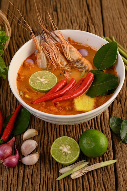 Free photo tom yum kung thai hot spicy soup shrimp with lemon grass,lemon,galangal and chilli on wooden table, thailand food