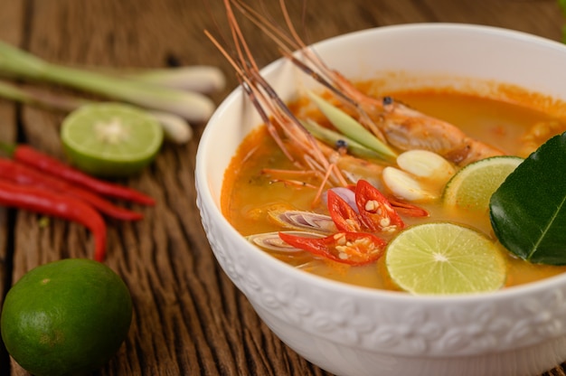 Free photo tom yum kung thai hot spicy soup shrimp with lemon grass,lemon,galangal and chilli on wooden table, thailand food