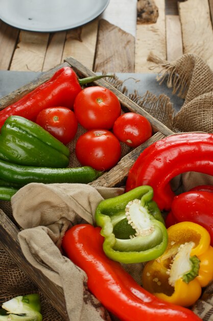 Free photo tomato, cucumber and peppers in a rustic tray. top view.