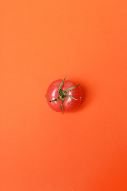 Free photo tomato isolated on red surface