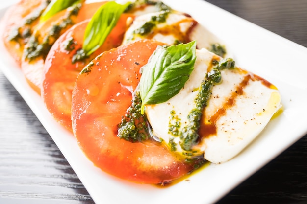 Tomato and mozzarella cheese salad in white plate