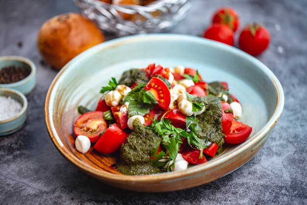 Tomato and mozzarella salad with pesto sauce and parsley