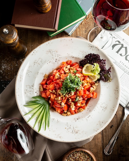 Free photo tomato and nut salad with lemon slice