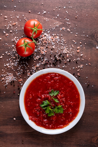 Free Photo tomato sauce and cherry tomatoes spreaded black pepper powder on brown stone surface