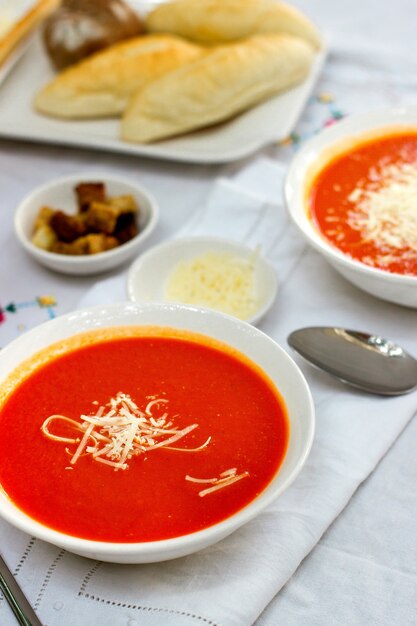 Tomato soup served with grated cheese and crackers