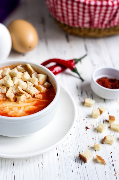 Tomato soup topped with crackers and cheese