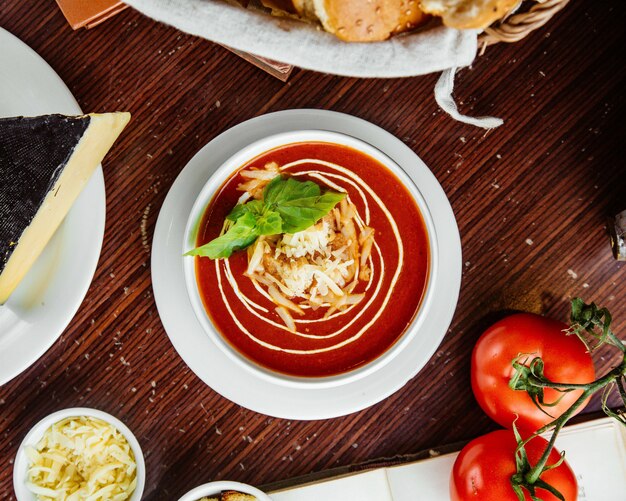  tomato soup with crackers and cheese tomatoes and bread on the table