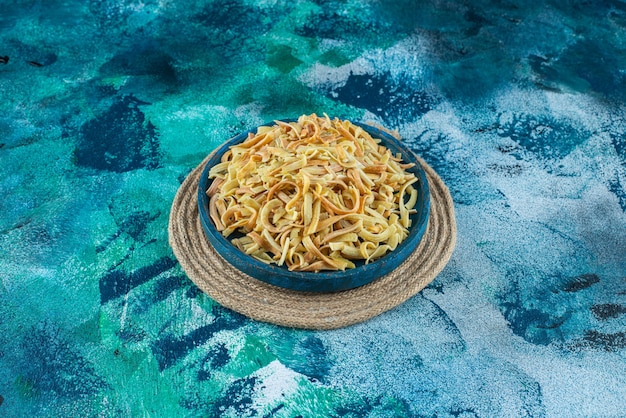 Free photo tomatoes, pepper and homemade noodle in a bucket , on the blue background.