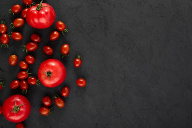 Tomatoes red cherry and usual tomatoes on grey floor