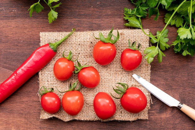 tomatoes on sacking with pepper and knife top view concept