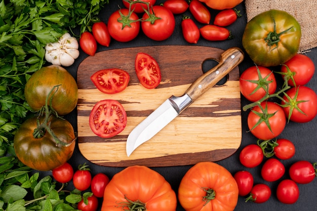 tomatoes top view concept with knife on cutting board