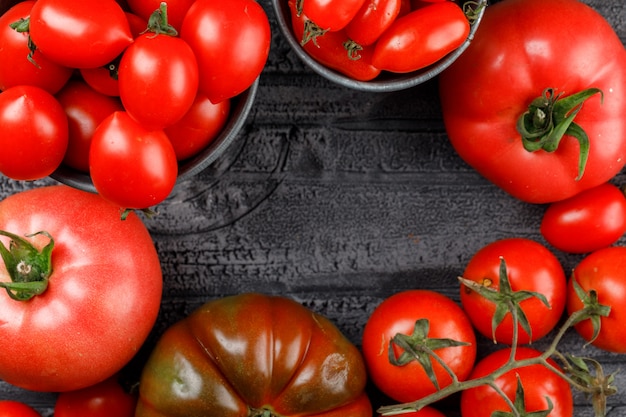 Free photo tomatoes variety in mini buckets on grey wooden wall, close-up.