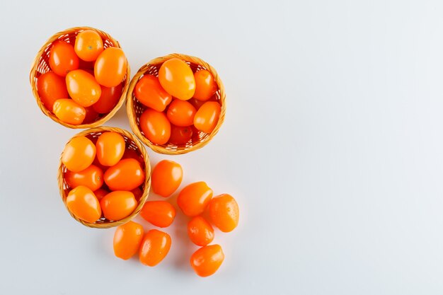 Tomatoes in wicker baskets flat lay