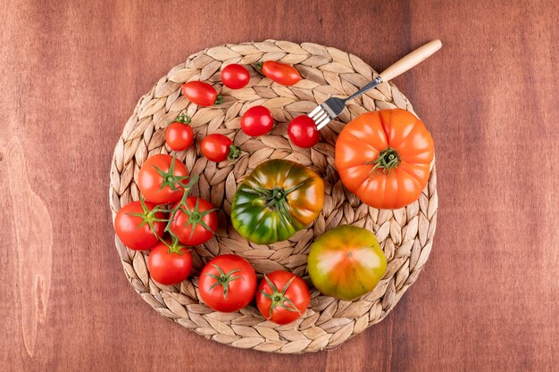 tomatoes with fork top view on wood table