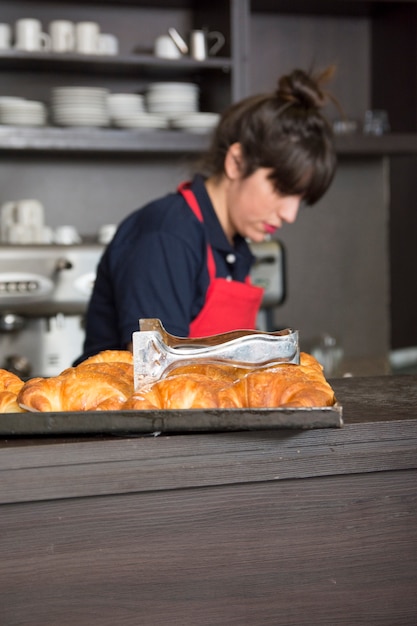 Free Photo tong over the baked croissant tray on counter in the caf�