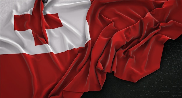 Free photo tonga flag wrinkled on dark background 3d render