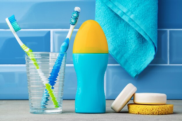 The toothbrushes in a glass in blue bathroom