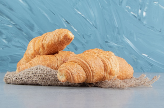 Toothsome croissants on towel , on the blue background. High quality photo