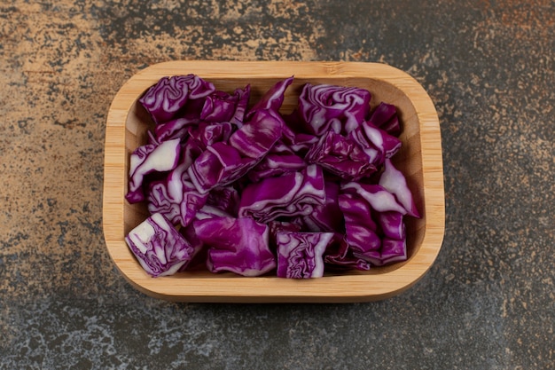 Toothsome red cabbage in the bowl , on the marble surface