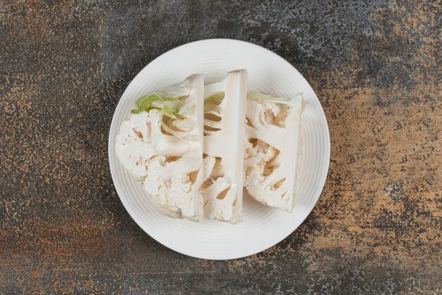 Toothsome sliced cauliflower on the plate, on the marble surface