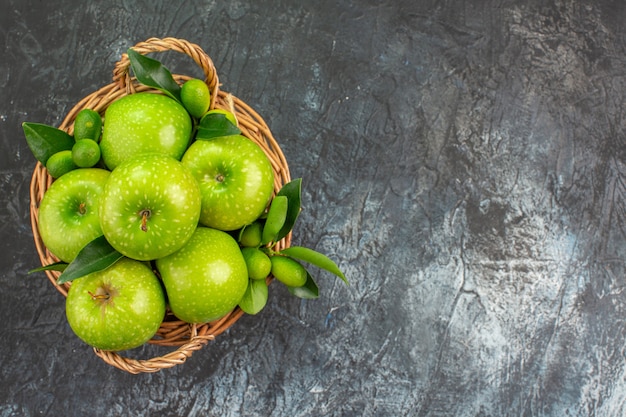 Free photo top close-up view apples the appetizing green apples with leaves in the wooden basket