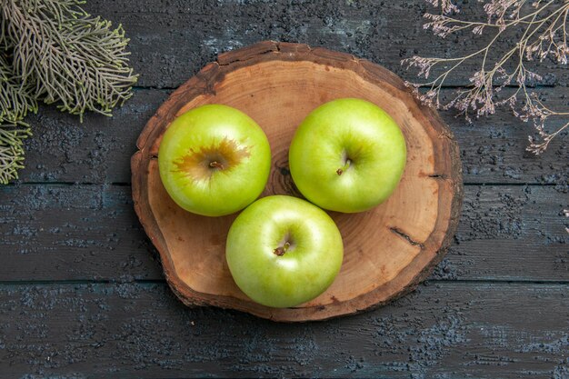 Top close-up view apples on board green apples on wooden board between tree branches