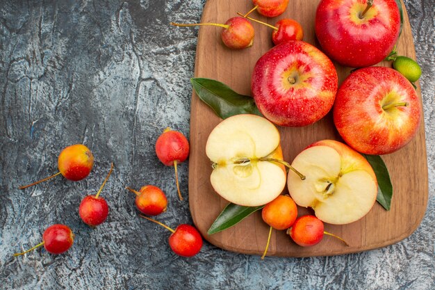 Top close-up view apples red apples cherries on the cutting board