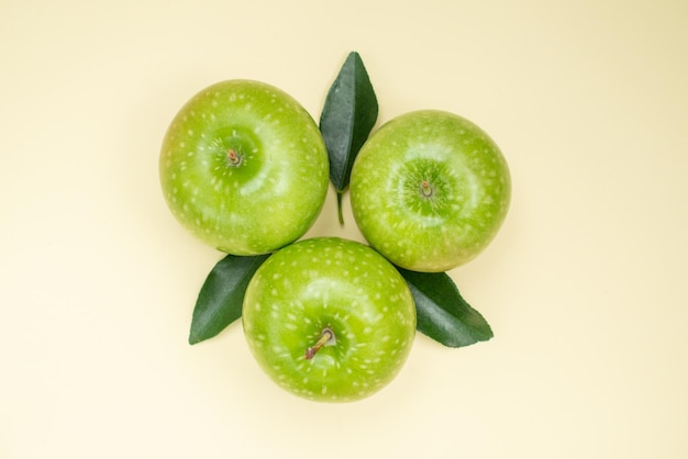 Top close-up view apples three appetizing apples with leaves on the white surface