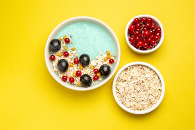 Top close-up view berries the appetizing colorful berries and oatmeal in the bowls