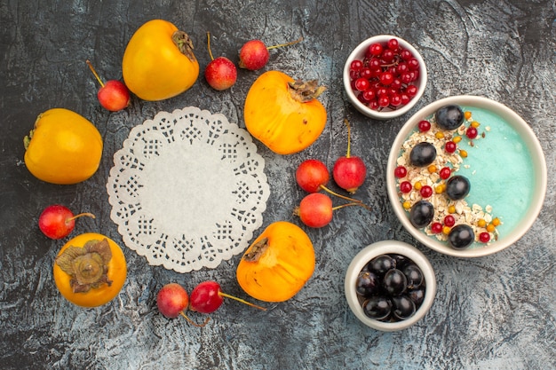 Free Photo top close-up view berries cherry persimmons around lace doily bowls of red currants grapes