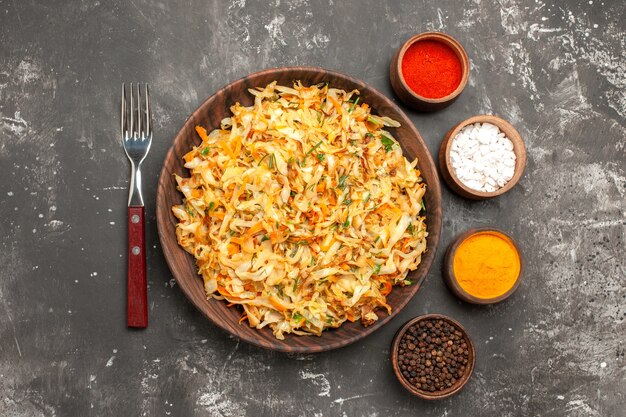 Top close-up view cabbage brown plate of cabbage fork bowls of colorful spices