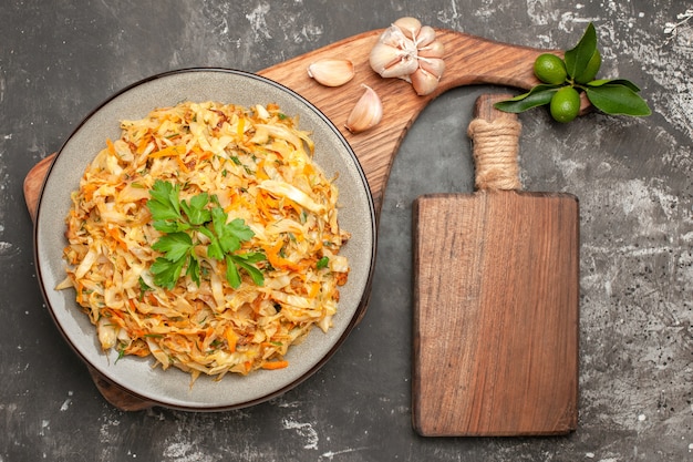 Top close-up view cabbage dish of cabbage garlic citrus fruit on the board wooden board