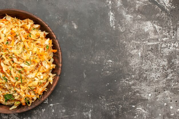 Top close-up view cabbage with carrots bowl of cabbage with carrots on the dark table