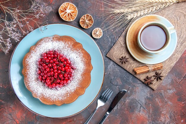 Top close-up view cake a cake a cup of tea cinnamon star anise lemon knife fork