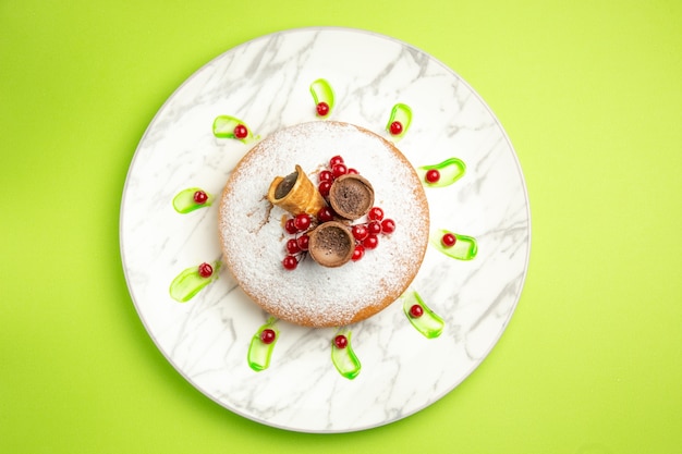 Free photo top close-up view a cake a cake with red currants waffles on the plate