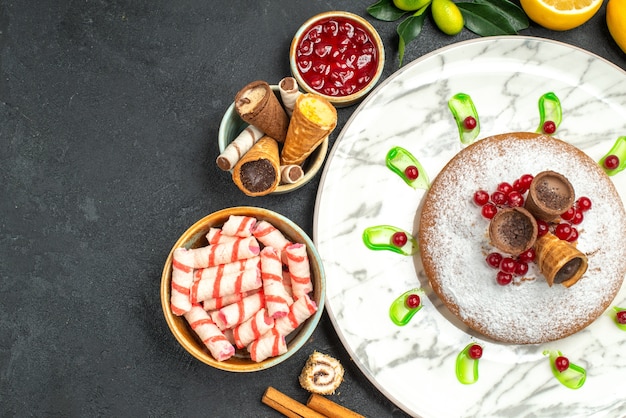 Top close-up view a cake plate of cake jam waffles citrus fruits cookies cinnamon sticks sweets