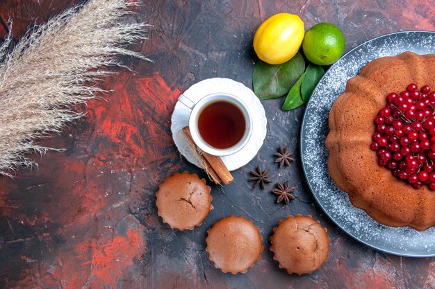 Top close-up view cake wheat ears cake citrus fruits cupcakes a cup of tea with cinnamon