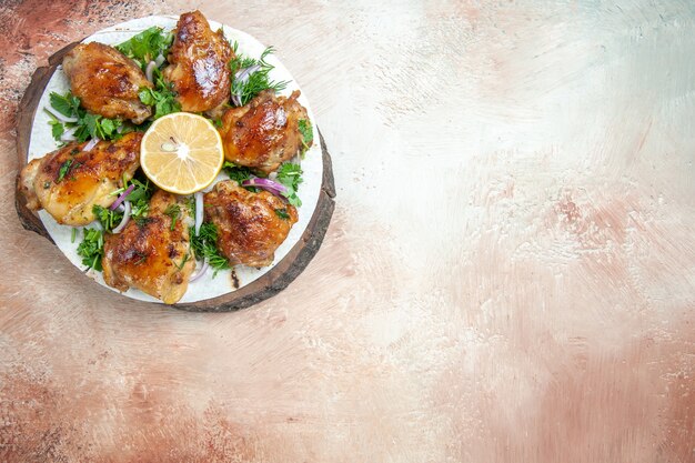 Free Photo top close-up view chicken an appetizing chicken with onion lemon herbs on lavash on the board