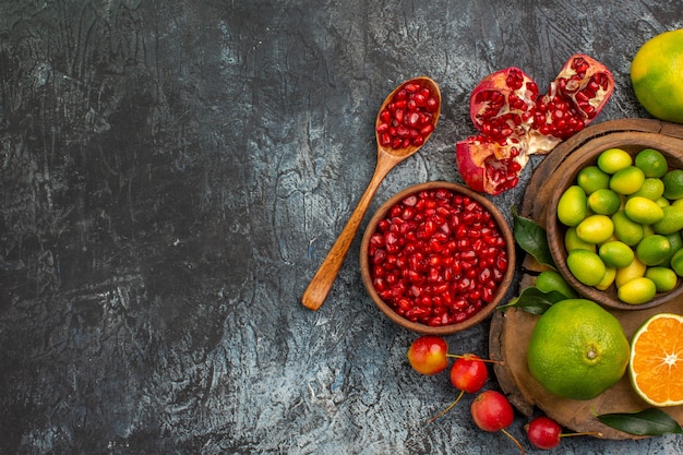 Top close-up view citrus fruits pomegranate seeds citrus fruits on the cutting board