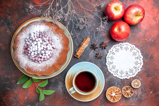 Top close-up view a cup of tea a cup of tea a cake star anise apples branches lace doily