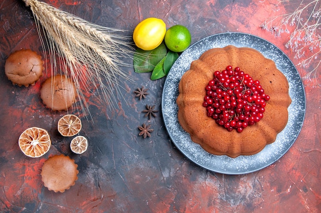 Top close-up view a cup of tea cupcakes lemon star anise cake on the plate branches wheat ears