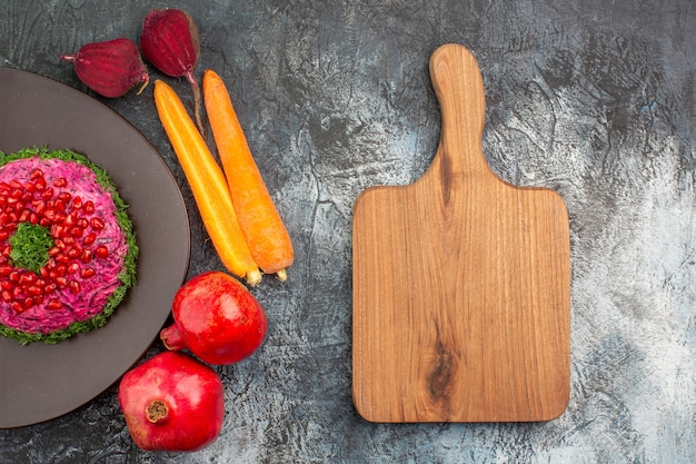 Top close-up view dish an appetizing dish pomegranates vegetables the cutting board