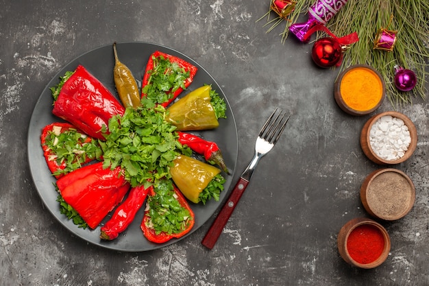 Free photo top close-up view dish peppers with herbs colorful spices christmas tree toys fork