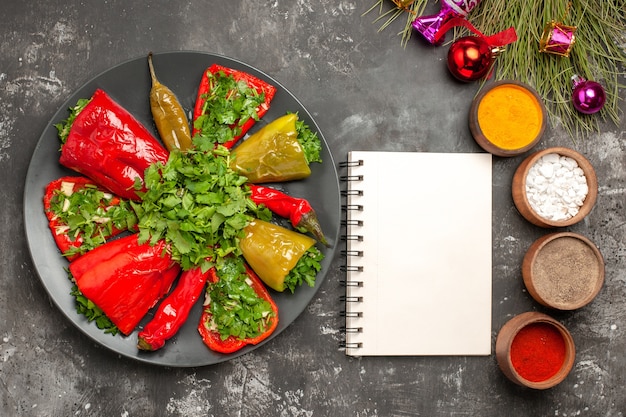 Free Photo top close-up view dish peppers with herbs colorful spices christmas tree toys white notebook