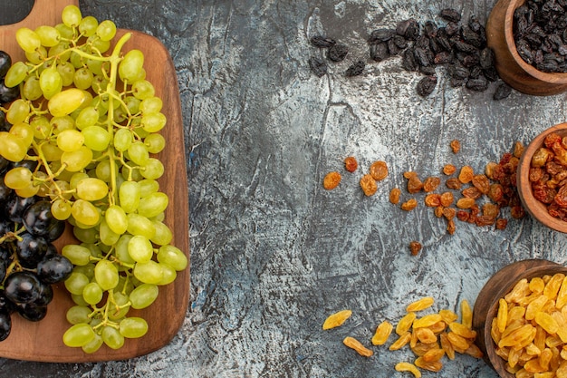 Free photo top close-up view dried fruits colorful dried fruits the appetizing grapes on the cutting board