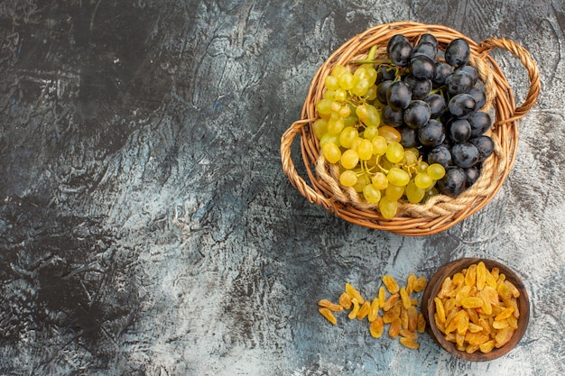 Top close-up view fruits dried fruits in the bowl the appetizing green and black grapes